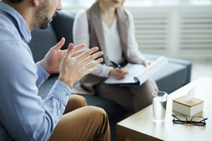 a man talks to a therapist at the action recovery program