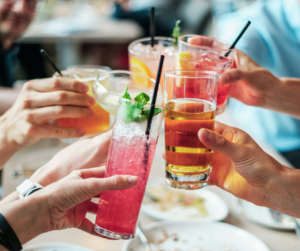 People's hand toasting with alcoholic beverages 