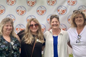 Group Photo of Employees in front of 40th Anniversary Sign 